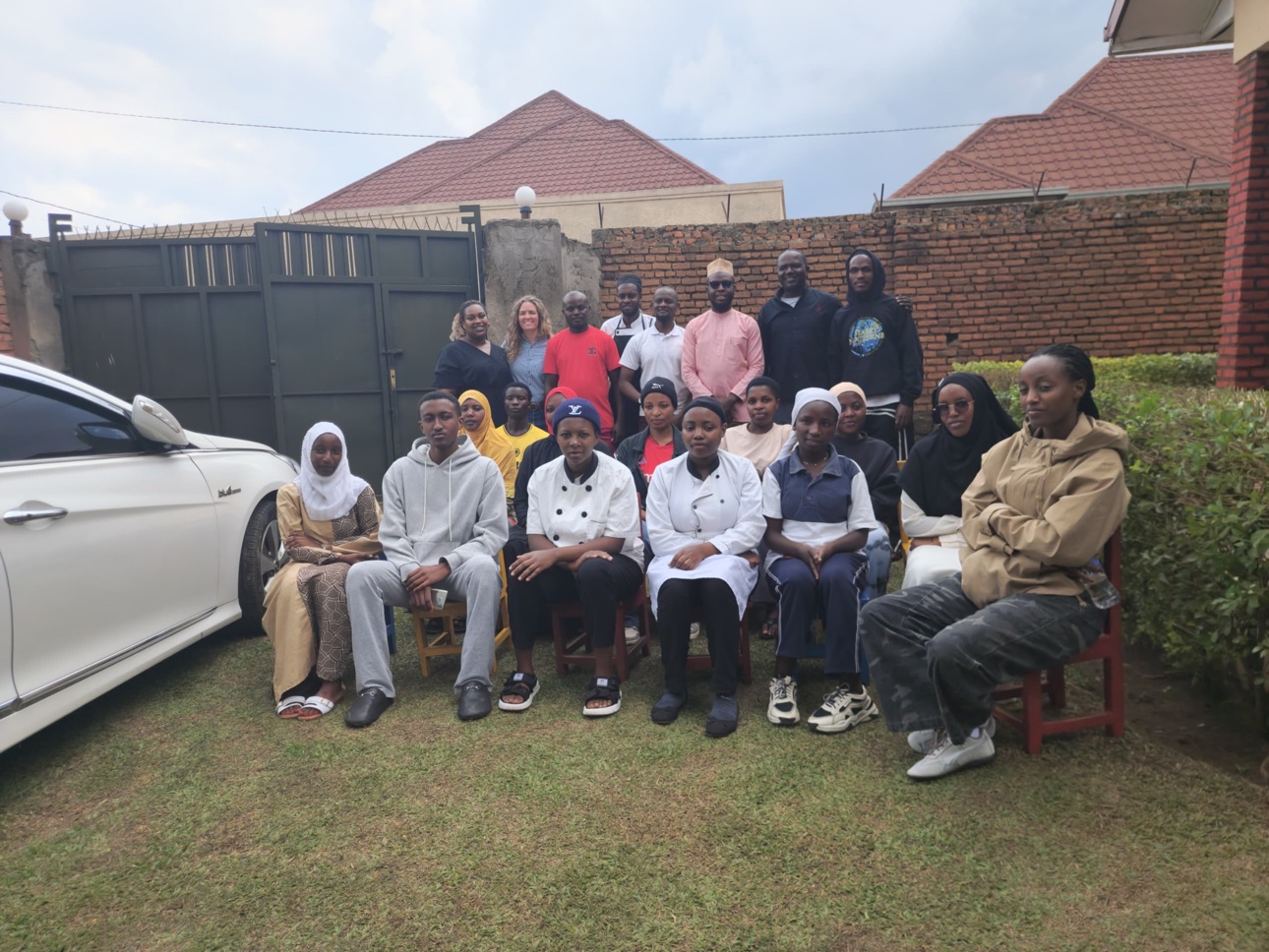 A group gathered together in Musanze, including people wearing hospitality uniforms.