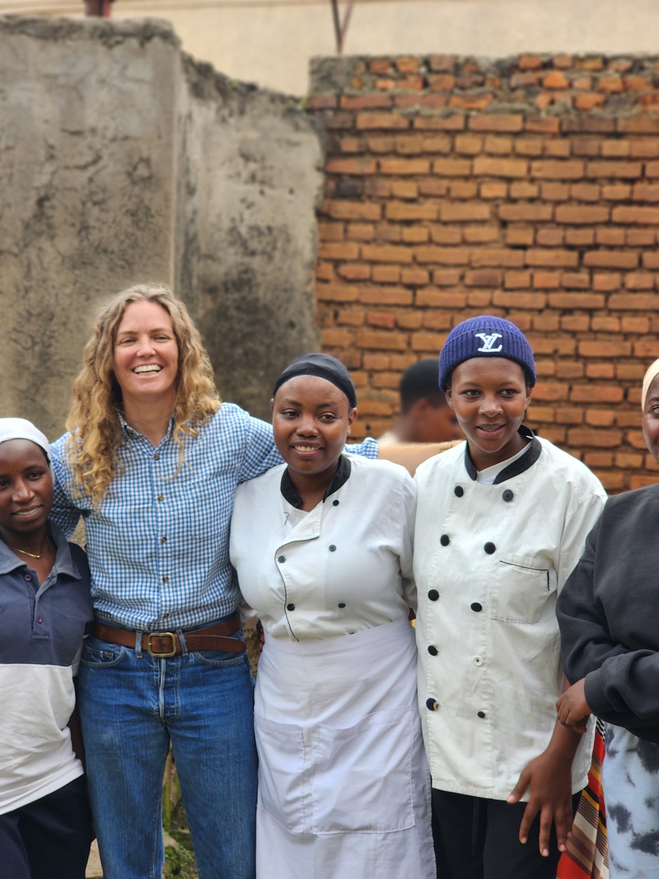 A group gathered together in Musanze, including people wearing hospitality uniforms.